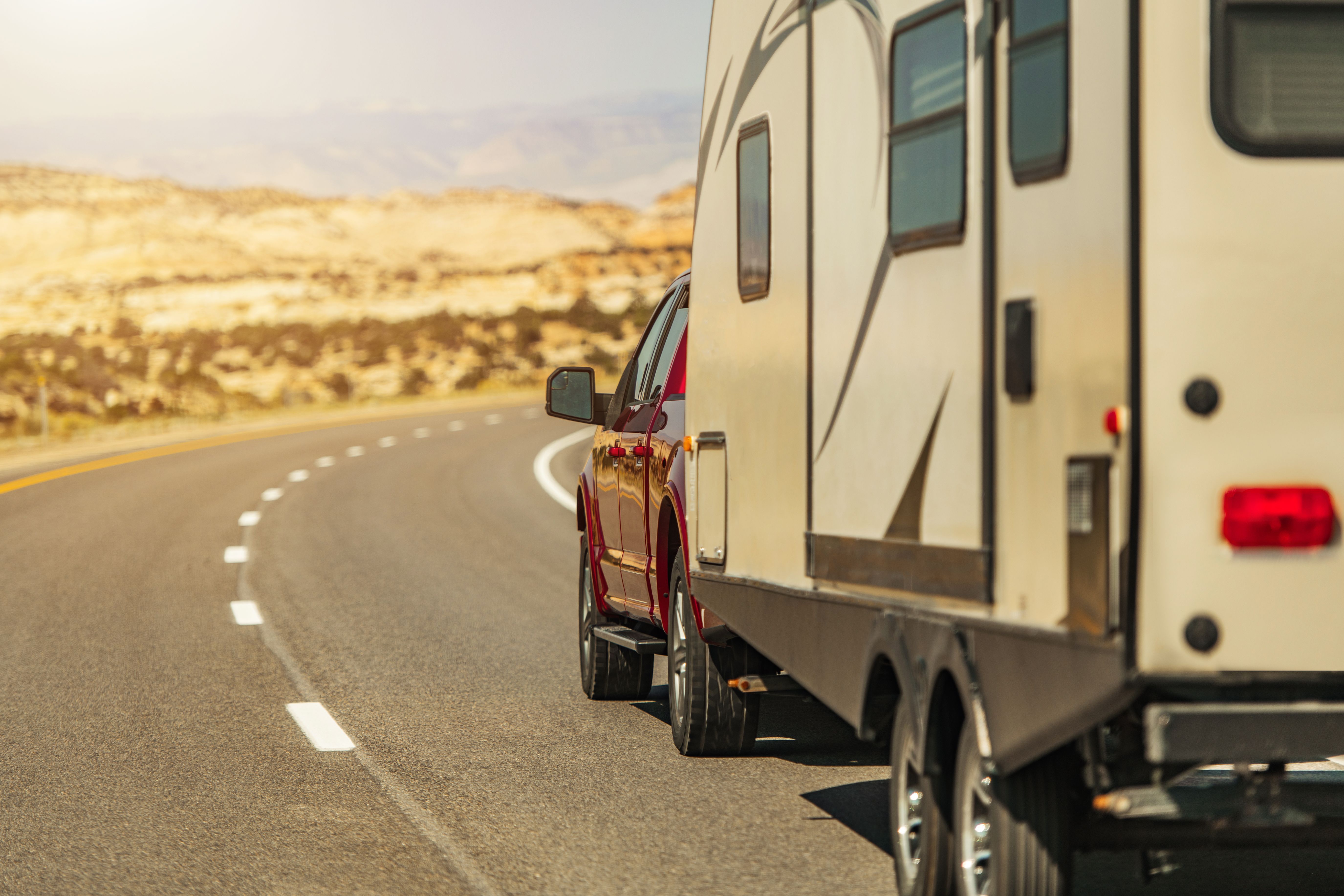 pickup truck pulling a travel trailer on a highway demonstrating how to tow a travel trailer